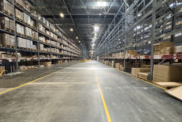 industrial commercial real estate includes large industrial warehouses with organized shelving and lighting